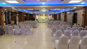 um salão vazio com cadeiras e um palco ao fundo em Hotel Vilas, Prayagraj em Allahābād