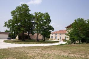 an old house with a tree and a road at Le Clos Saint-Jean - Chambre d'hôte Rosie in Saint-Jean-de-Thurac