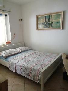 ein Bett in einem Schlafzimmer mit einem Bild an der Wand in der Unterkunft Studio apartman Lina in Gradac