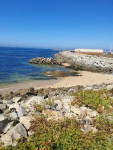 une plage avec des rochers et l'océan en arrière-plan dans l'établissement Guest house near the beach, à Vila do Conde
