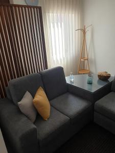 - un canapé avec deux oreillers et une table dans le salon dans l'établissement Guest house near the beach, à Vila do Conde