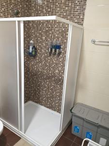 La salle de bains est pourvue d'une douche avec une porte en verre. dans l'établissement Guest house near the beach, à Vila do Conde