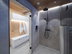 La salle de bains est pourvue d'une douche et d'un lavabo. dans l'établissement Villa Forest, à Rovaniemi