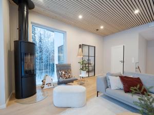 sala de estar con sofá y chimenea en Villa Forest en Rovaniemi