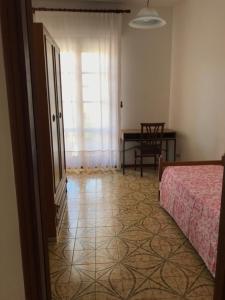 1 dormitorio con 1 cama y 1 mesa con silla en Casa Mariano IV (IUN Q8167), en Oristano