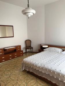 1 dormitorio con cama, tocador y espejo en Casa Mariano IV (IUN Q8167), en Oristano