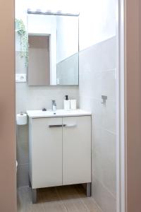 een witte badkamer met een wastafel en een spiegel bij Apartamento Rauda 51 B, Granada in Granada