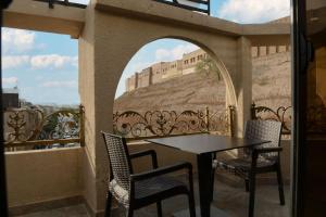 a balcony with a table and chairs and a wall at Syros Hotel Erbil City Center in Erbil +24 photos