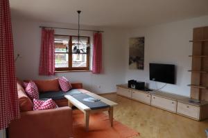 a living room with a couch and a tv at Ferienhaus Pfeiffer in Schwangau