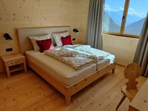 1 dormitorio con 1 cama en una habitación con ventana en Ferienhütte Premstlahof - Chalet en Martello
