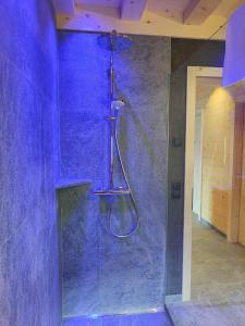 y baño con ducha y pared púrpura. en Ferienhütte Premstlahof - Chalet, en Martello