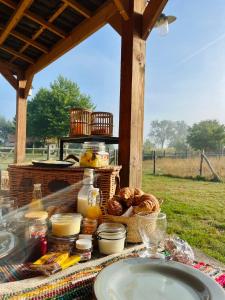 a picnic table with plates of food and bread at Comfort Tipi Marie, Tipi Bo Deluxe & tent Nicolaï - 'Glamping in stijl' in Lembeke