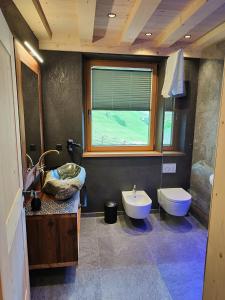 a bathroom with a sink and a toilet at Ferienhütte Premstlahof - Chalet in Martello