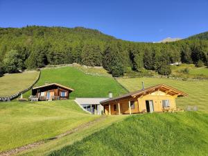 una casa en medio de un campo verde en Ferienhütte Premstlahof - Chalet, en Martello