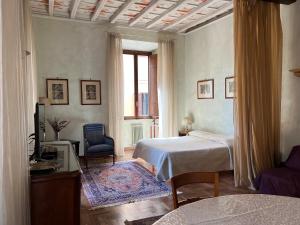 ローマにあるドムス ミネルヴァエのベッドルーム1室(ベッド1台、椅子、窓付)