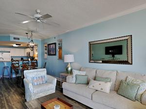 a living room with a couch and chairs and a kitchen at Palacio #1003 in Perdido Key