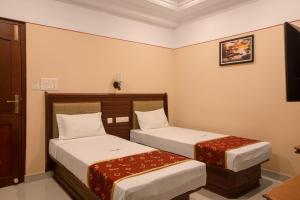 two beds in a hotel room with two beds at Hotel Vashanth Krishna in Nāgercoil