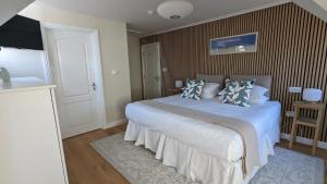 a bedroom with a large white bed with pillows at Beach Lodge in Bournemouth