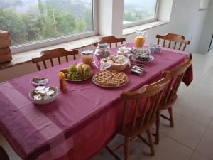 uma mesa com uma toalha de mesa roxa com comida em Agriturismo Il cielo in terra em SantʼOreste