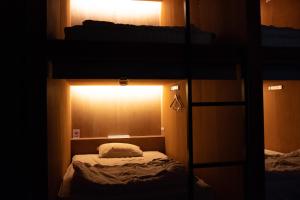 a room with a bunk bed with a light on it at Guesthouse Sunline Beppu in Beppu