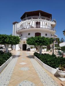 a large white building with a balcony on top at Arenella Beach Rooms in Arenella