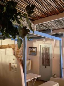 una habitación con una mesa y una puerta con una planta en Golden Beach, Little Troll House 3, en Chrissi Akti