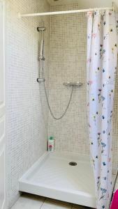 a bathroom with a shower with a shower curtain at La Mandragora - Maison avec jardin et poêle à bois in Vernon