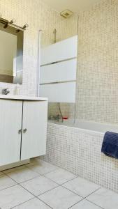 uma casa de banho com uma banheira, um lavatório e um espelho. em La Mandragora - Maison Vernon Giverny em Vernon