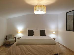 Un dormitorio con una cama grande y una lámpara de araña. en MAS DU RECATI, en Caderousse
