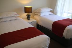 two beds sitting next to each other in a room at Wagga Showground Villas in Wagga Wagga