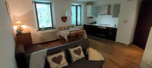 a living room with a couch and a kitchen at Rododendro 10 in Tarvisio