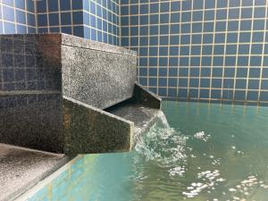 a water fountain in front of a building at Guesthouse Sunline Beppu in Beppu +112 photos