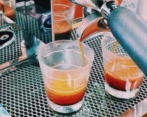 two cups sitting on a metal table with a juicer at Guesthouse Sunline Beppu in Beppu