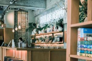a restaurant with a counter with a person sitting at it at Guesthouse Sunline Beppu in Beppu