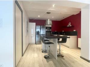 kuchnia z blatem i stołkami w pokoju w obiekcie Appartement 90m2 design, jacuzzi, billard... w mieście Vitré