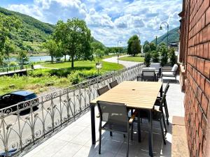 a table and chairs on a balcony with a view of a river at Direct Moselle view 200m² 4 SZ 10Pers Terrace in Sankt Aldegund