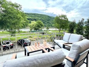 a patio with couches and a table on a balcony at Direct Moselle view 200m² 4 SZ 10Pers Terrace in Sankt Aldegund
