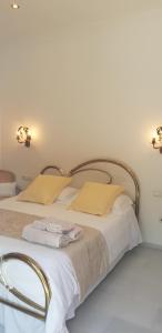 a bed with white sheets and yellow pillows at Villa Amadeus Xabia in Balcon del Mar +52 photos