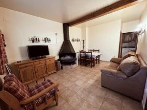 a living room with a couch and a tv at Complejo Rural La Glorieta in Catí