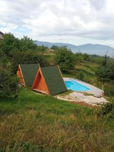 a small house with a swimming pool in a field at Bungalovi Lana in Sarajevo