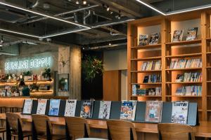 biblioteka ze stołem, krzesłami i książkami w obiekcie Guesthouse Sunline Beppu w mieście Beppu