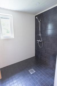 a bathroom with a shower with blue tile at Lomaperkkiö Cottages in Kajaani