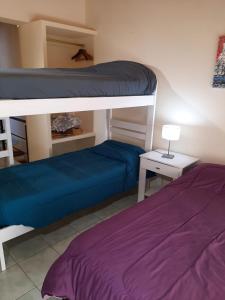 a bedroom with two bunk beds and a table with a lamp at La Chacrita in Plottier