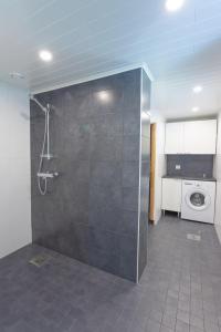 a bathroom with a shower and a washing machine at Lomaperkkiö Cottages in Kajaani