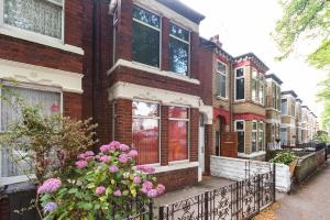 a row of houses with pink flowers in front of them at The Miracle Spacious 2 Bedroom 3 Beds Central Hull in Hull