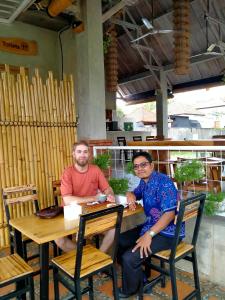 two men sitting at a table in a restaurant at Suta Lovina House in Lovina