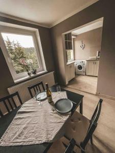 Franzis Feriendomizil im Herzgebirge am Skihang في Auerbach: غرفة طعام مع طاولة مع زجاجة من النبيذ