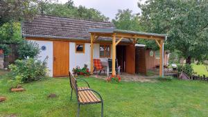 a small house with a bench in a yard at Pavlov24 - Zahradní domečky in Pavlov
