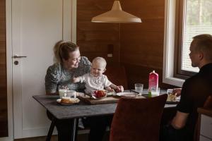 een vrouw aan een tafel met een baby bij Min Ája in Karasjok