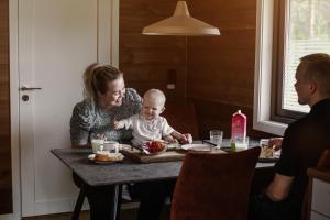 a woman sitting at a table with a baby at Min Ája in Karasjok